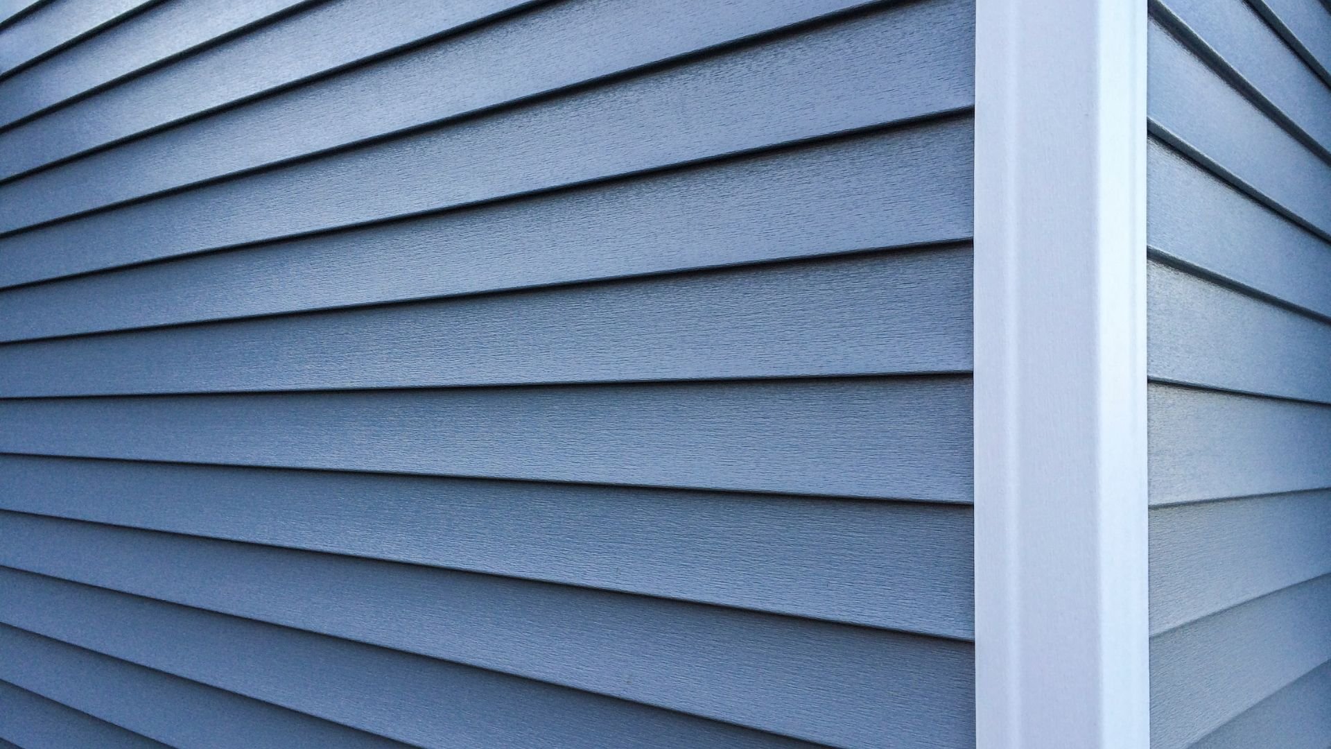 Blue-gray horizontal siding on a house exterior with vertical corner trim